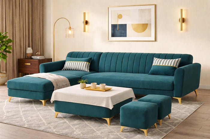 A modern teal velvet sectional sofa set in a styled living room, including a chaise lounge, matching ottomans, a low coffee table with a white throw, and striped accent pillows.